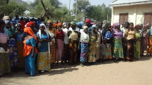 Women wait in line to receive food supplies.